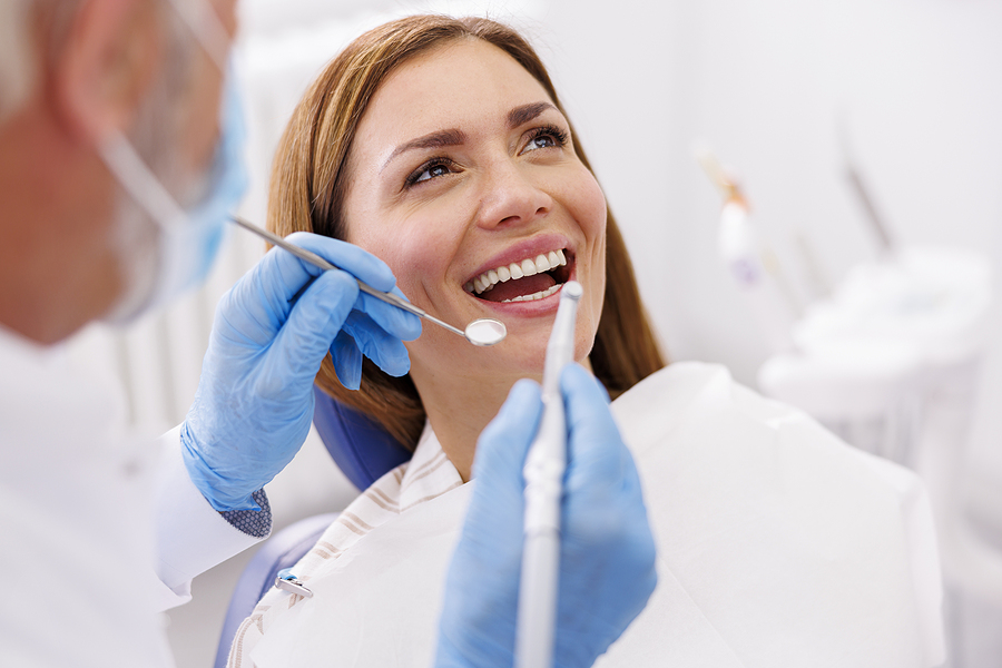 Dentist Fixing Patient's Tooth At Dental Clinic Using Dental Dri